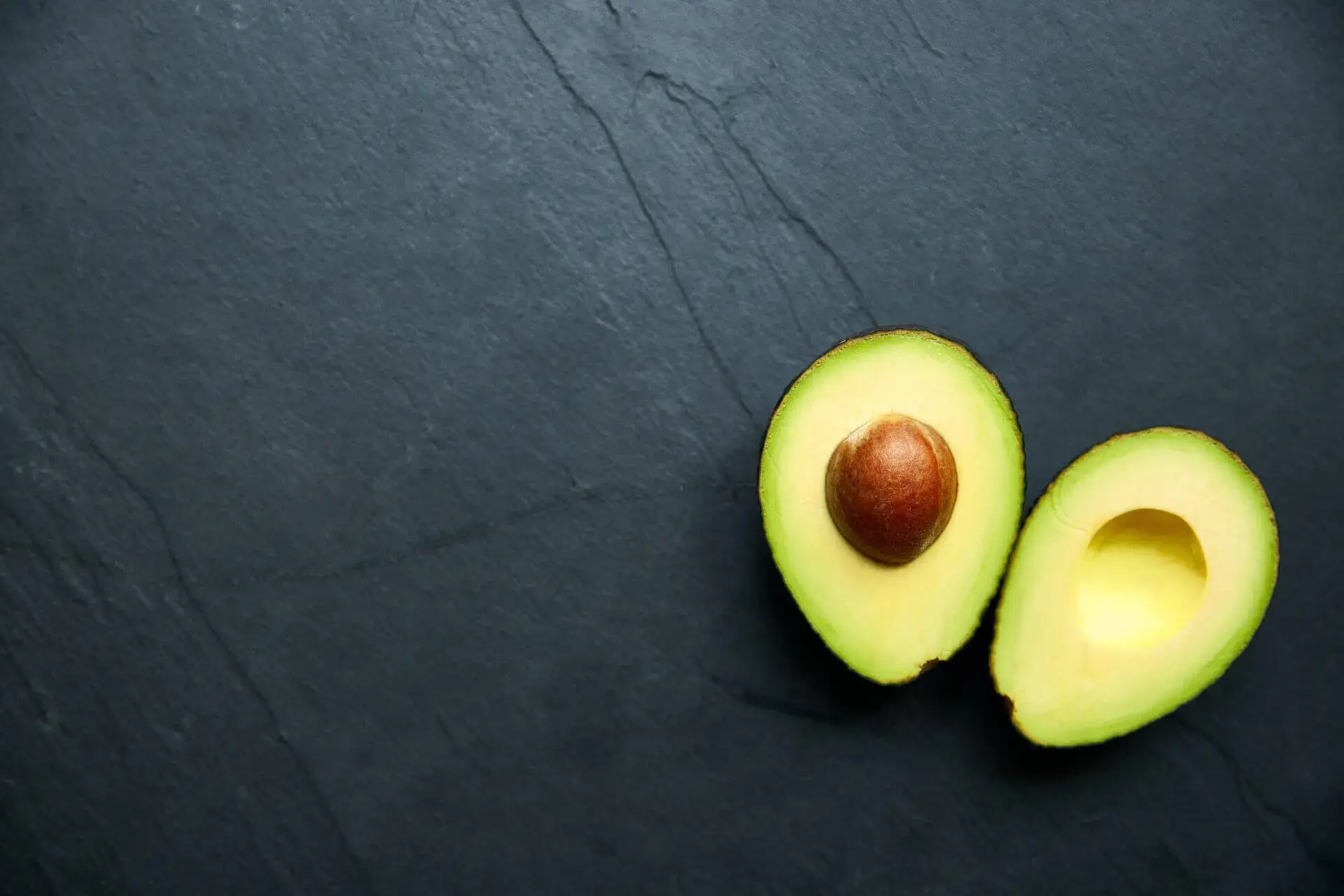 Ripe Avocado cut in halve with pit showing
