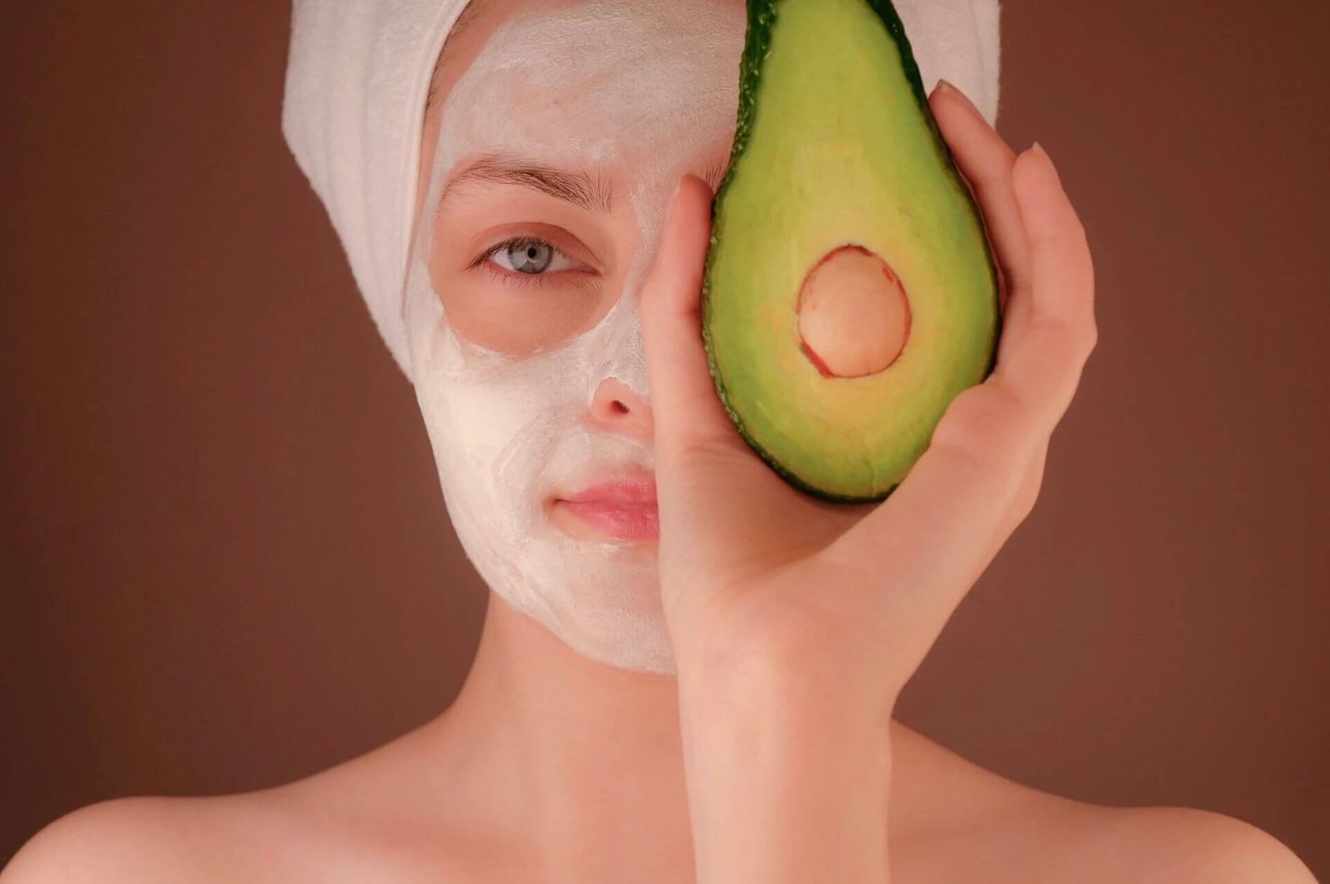Woman with halve avocado for skincare